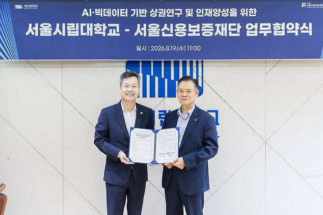 원용걸 서울시립대 총장(왼쪽)이 서울신용보증재단 최항도 이사장과 지난 19일 'AI·빅데이터 기반 상권연구 및 인재양성을 위한 업무협약(MOU)'을 체결한 뒤 기념촬영을 하고 있다. 서울시립대 제공