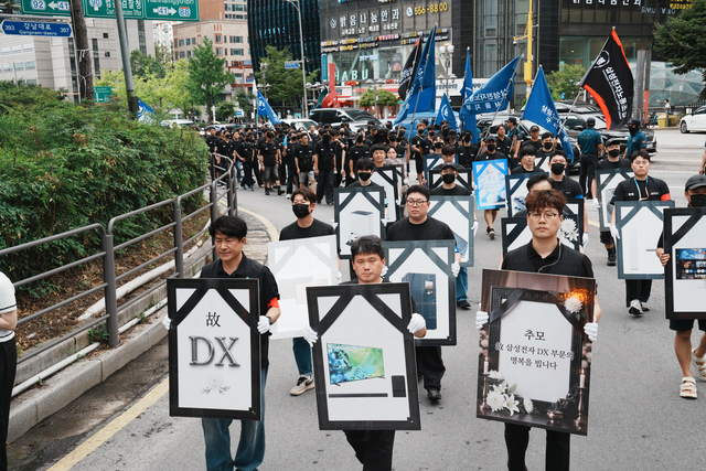 삼성전자노조동행이 21일 서울 강남역 일대에서 ‘DX’ 영정사진 판넬을 들고 가두행진을 벌이고 있다. 동행노조 제공