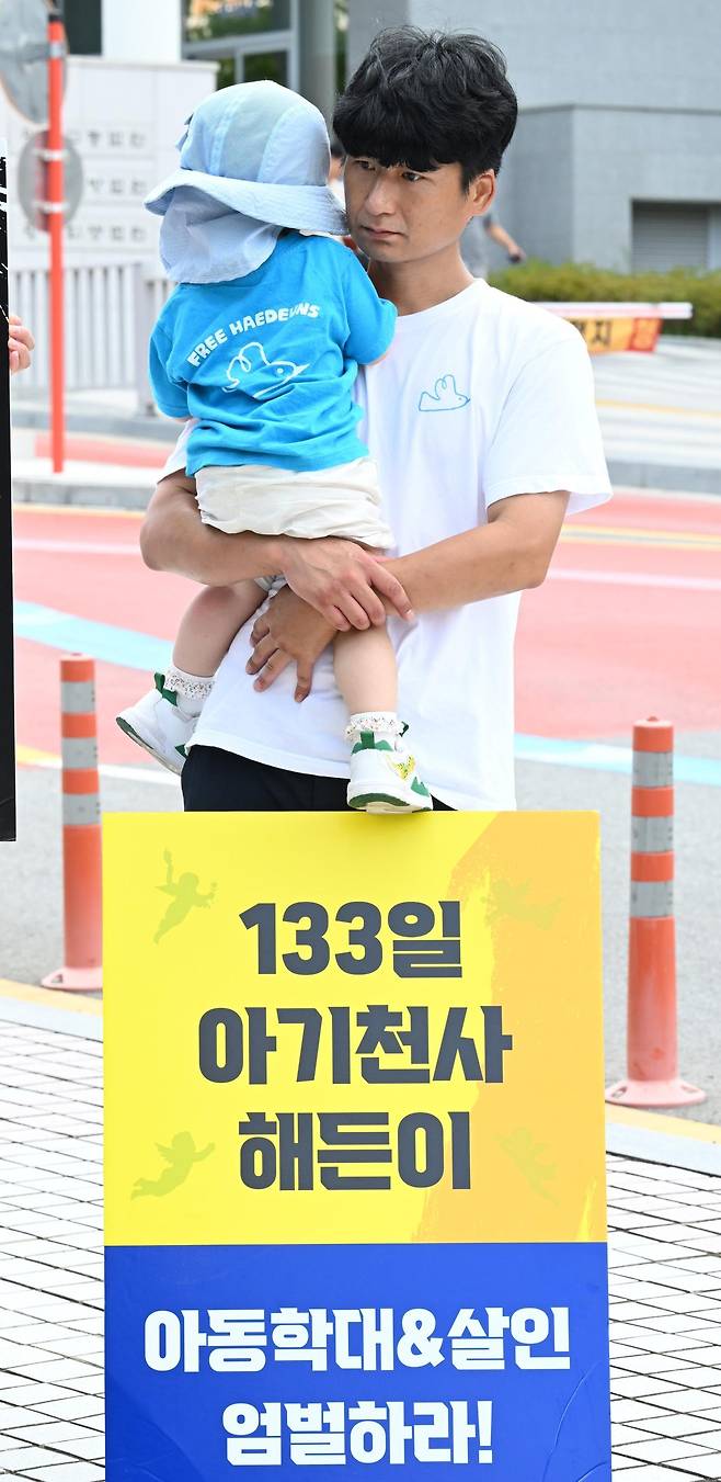 프리해든스 시민모임이 25일 오후 전남광주 동구 광주지법 앞에서 해든이 추모 집회를 열고 있는 가운데 한 아빠가 아이를 안고 집회에 참여하고 있다. 뉴시스