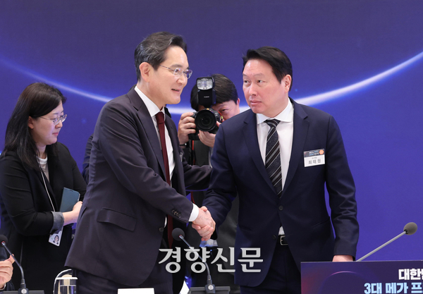 이재용 삼성전자 회장(왼쪽)과 최태원 SK그룹 회장이 지난 6월29일 청와대에서 열린 ‘대한민국 대도약 3대 메가프로젝트 국민보고회’에서 만나 악수를 나누고 있다. 청와대사진기자단