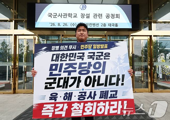 26일 오후 국군사관학교 창설 공청회가 열린 서울 용산구 국방컨벤션 앞에서 한 시민이 사관학교 통합 반대 1인 시위를 하고 있다. 2026.8.26 ⓒ 뉴스1 최지환 기자