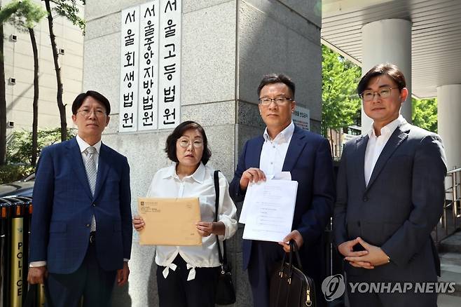 "북에서 인권침해 당했다"며 김정은 상대 민·형사 소송 (서울=연합뉴스) 윤동진 기자 = 최민경 북한감금피해자가족회 대표(왼쪽 두 번째)가 11일 서울중앙지방법원에 민사 소장을 제출하기 앞서 고소장을 들어보이고 있다. 2025.7.11 mon@yna.co.kr