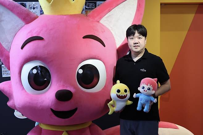 김민석 더핑크퐁컴퍼니 대표이사 (서울=연합뉴스) 류효림 기자 = 김민석 더핑크퐁컴퍼니 대표이사가 최근 서울 서초구 사옥에서 연합뉴스와의 인터뷰에 앞서 포즈를 취하고 있다. 2026.8.29 ryousanta@yna.co.kr
왼쪽 큰 조형물은 핑크퐁, 김 대표가 들고 있는 인형은 아기상어(왼쪽), 베베핀(오른쪽).