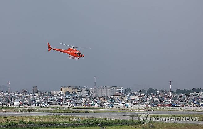 먹구름 깔린 카트만두 공항 (카트만두=연합뉴스) 김성민 기자 = 28일(현지시간) 네팔 카트만두 트리부반 국제공항에서 이동하는 헬기 뒤로 먹구름이 깔려 있다. 네팔 정부는 기상 여건등과 추가 붕괴 우려 등으로 현지 헬기 운행을 제한하는 등의 조치를 시행하고 있다. 2026.8.28 ksm7976@yna.co.kr