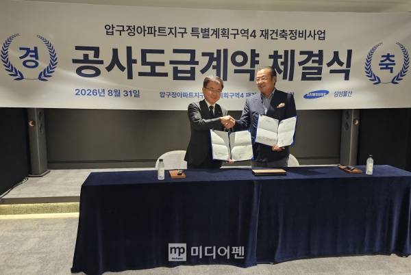 임철진 삼성물산 주택영업본부장(왼쪽)과 김윤수 압구정4구역 조합장이 31일 공사도급계약서에 사인 후 악수를 하고 있다./사진=미디어펜 서동영 기자
