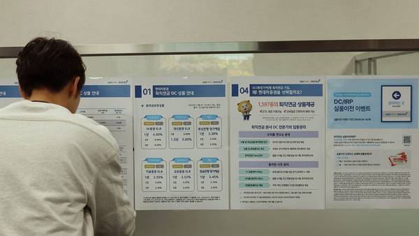증권사 영업점에서 관계자가 퇴직연금 관련 홍보물을 부착하는 모습. 사진=연합뉴스
