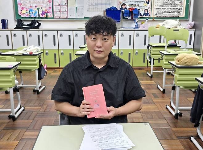 지난 26일 부산 학산여중에서 ‘한겨레’와 만난 최범준 교사(38)가 11년 동안 학부모에게 쓴 편지를 모아 출간한 책 ‘교실이 무너졌다고 생각할 당신에게’를 들고 있다. 이우연 기자