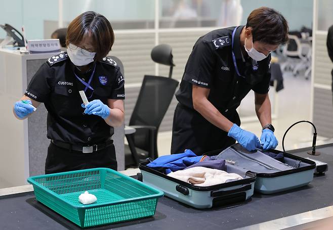 7월 22일 인천국제공항 제1여객터미널 입국장 마약전담 검사대에서 관세청 직원들이 수하물 속 마약밀수 단속 시연을 펼치고 있다. /뉴스1