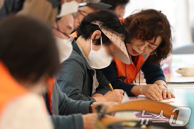경기 수원시 팔달구 화성행궁 광장에서 열린 '수원시 노인일자리 채용한마당'에서 중장년 구직자들이 이력서를 작성하고 있다. ⓒ 뉴스1 김영운 기자
