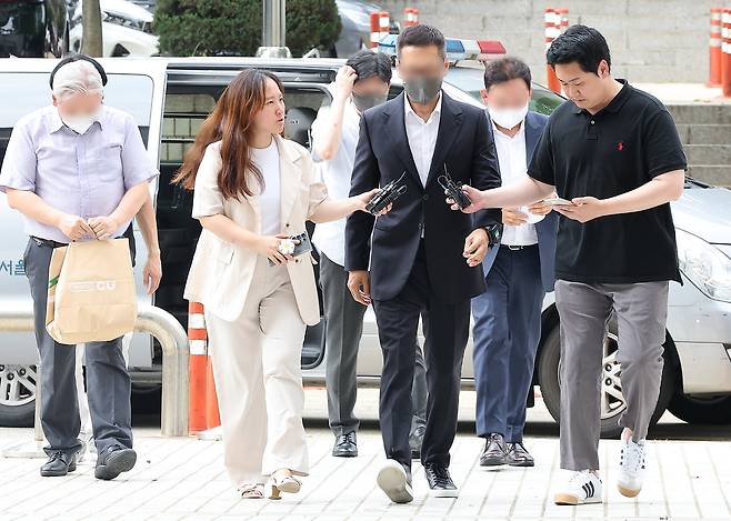 김영준 이그룹(옛 이화그룹) 회장(왼쪽 네 번째)이 서울중앙지방법원에서 열린 구속 전 피의자 심문(영장실질심사)에 출석하고 있다./뉴스1