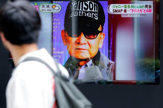 한 남성이 2019년 7월 10일 일본 도쿄의 한 전광판을 통해 일본 대형 연예기획사 쟈니스의 창업주 쟈니 기타가와가 전날 사망했다는 뉴스를 보고 있다. 도쿄=교도·AP 연합뉴스 자료사진