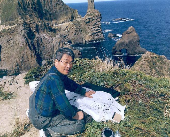 독도에서 붓 대신 손끝으로 지두화(指頭畵) ‘독도진경’을 그리고 있는 이종상 화백. 이종상 화백 제공