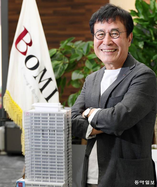 지난달 20일 서울 성북구 보미건설 회장실에서 김덕영 회장이 우즈베키스탄 타슈켄트에 보미건설이 지은 오피스 빌딩 ‘보미 파이낸스 센터(BFC)’ 모형 앞에서 포즈를 취하고 있다. 전영한 기자 scoopjyh@donga.com
