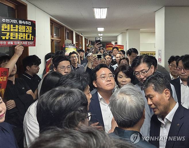 주민들에게 가로막힌 진교훈 구청장과 한정애 의원 (서울=연합뉴스) 오진송 기자 = 11일 서울 강서구 염경중학교에서 열린 염창공원 공공주택지구 지정 주민설명회에서 진교훈 강서구청장(가운데)과 지역구 국회의원인 더불어민주당 한정애 의원이 주민들의 항의에 가로막혀 있다. 2026.9.11 dindong@yna.co.kr