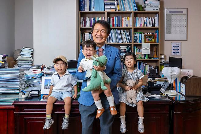 기업과 학계가 참여한 ‘2100년 한국 합계출산율 2.1명 회복, 인구 3000만 사수’ 캠페인을 이끄는 김종훈 한미글로벌 회장이 서울 삼성동 본사 집무실에서 직원 자녀들과 함께 포즈를 취했다. 품에 안은 아기는 이 회사의 무제한 난임 시술 지원 정책으로 태어난 태준(1세)군. 양 옆엔 육아휴직 중인 남성 직원의 아들 건호(3·왼쪽)군과 육아기 재택근무 중인 여성 직원의 딸 윤슬(3)양이다. /이신영 영상미디어 기자