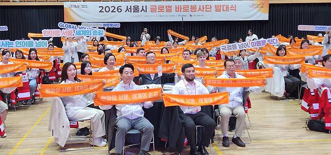 13일 서울시청 본관에서 열린 글로벌 바로봉사단 발대식에서 참석자들이 '한마음 서울, 세계의 손길' 슬로건을 들고 봉사단 출범을 기념하고 있다. 서울시 제공