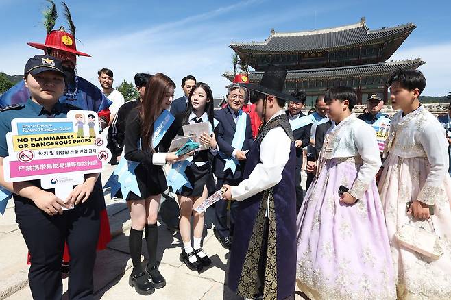 허민 국가유산청장과 홍보대사 피프티피프티 예원ㆍ아테나가 17일 서울 경복궁 일원에서 열린 궁능 관람 질서 준수 유관기관 합동캠페인에서 관람객들에게 홍보물을 배포하고 있다. 연합뉴스
