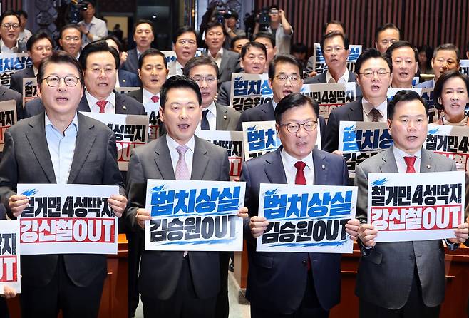 국민의힘의 장동혁 대표와 정점식 원내대표를 비롯한 의원들이 17일 국회에서 열린 의원총회에서 '철거민 4성딱지 강신철 OUT', '법치상실 김승원 OUT' 피켓을 들고 구호를 외치고 있다. 연합뉴스