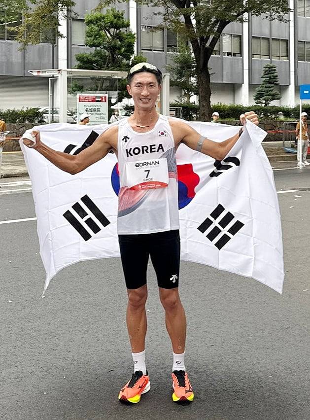 최병광이 23일 일본 나고야에서 열린 2026 아이치 나고야 아시안게임 남자 하프마라톤 경보에서 3위를 차지한 뒤 태극기를 몸에 두르고 포즈를 취하고 있다. /대한육상연맹