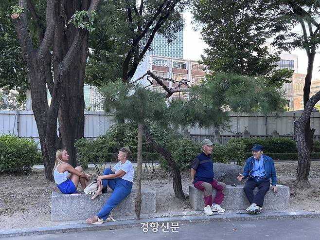 21일 외국인 관광객들과 노인들이 서울 종로구 탑골공원에 벤치에 앉아 대화를 나누고 있다. 임주영 기자