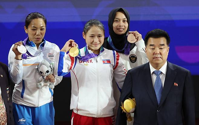 이날 일본 나고야 중소기업진흥회관에서 열린 2026 아이치·나고야 아시안게임 역도 여자 49㎏ 결승에서 금메달을 획득한 북한 리성금이 시상대에 올라 김일국 북한 체육상과 기념촬영을 하고 있다. / 사진 = 연합뉴스