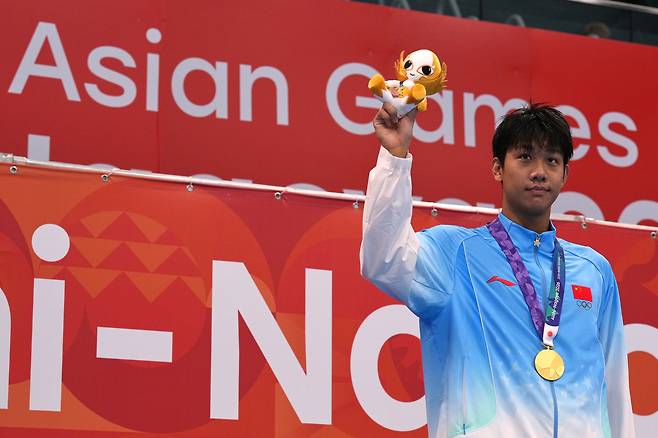 중국 장잔숴가 지난 24일 일본 도쿄에서 열린 2026 아이치·나고야 아시안게임 수영 남자 자유형 800m 결승에서 금메달을 딴 뒤 시상대에서 메달을 들어 보이고 있다. AP연합뉴스