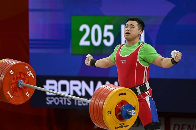 북한 로광렬이 28일 일본 나고야시 중소기업진흥회관에서 열린 2026 아이치·나고야 아시안게임 역도 남자 85㎏급 용상 3차 시기에서 214㎏을 성공시킨 뒤 바벨을 내려놓고 있다. 로광렬은 이 시기로 용상 214㎏, 합계 379㎏의 세계신기록을 세우며 금메달을 확정했다. 나고야=하상윤 기자