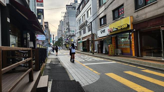 '킥보드 없는 거리' 정식 운영을 이틀 앞둔 지난 28일 서울 강남구 대치동 학원가 길목에 10대 학생 2명이 킥보드를 함께 타고 지나가고 있다. /사진=황지민 기자