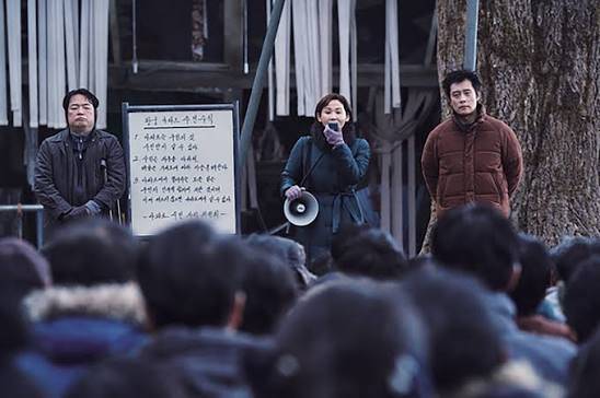 영화 콘크리트 유토피아에서 황궁아파트 주민들이 한데 모여 공동체의 규칙과 생존 방식을 정하는 장면. 주민들이 먼저 '우리'의 경계와 목표를 결정한다는 설정은 AI를 주민대표 자리에 넣는 이번 사고실험의 출발점이다. /롯데엔터테인먼트