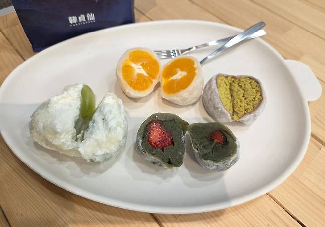 반으로 자른 한정선 찹쌀떡 4종. 왼쪽 샤인머스캣 요거트, 위쪽 통귤, 아래쪽 쑥 생딸기, 오른쪽 두바이 찹쌀떡의 속재료가 드러나 있다. (사진=한전진 기자)