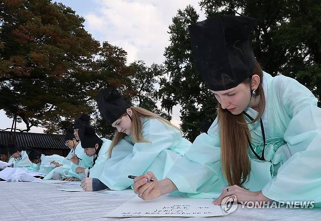 문제에 집중 (서울=연합뉴스) 이진욱 기자 = 성균관유도회총본부가 5일 서울 종로구 성균관 명륜당에서 주최한 '제1회 재한 외국인 과거 시험'에서 참가자들이 유건(儒巾)과 도포 차림으로 답안을 쓰고 있다. 2026.10.5 cityboy@yna.co.kr