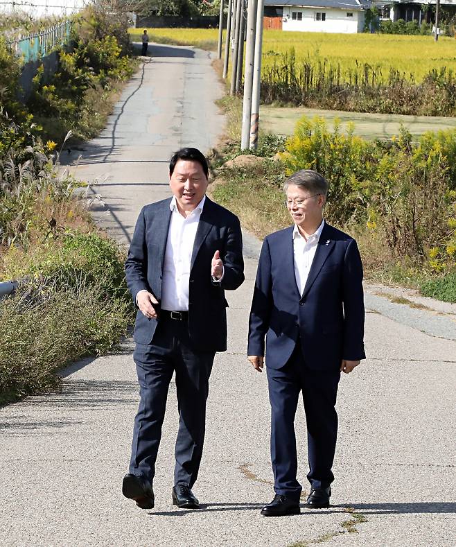 최태원 SK그룹 회장(왼쪽)이 9일 광주 탄약고 부지를 방문해 민형배 전남광주통합특별시장(오른쪽)과 함께 현장을 둘러보며 대화를 나누고 있다. SK하이닉스