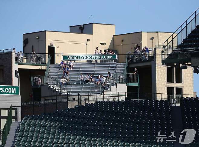 MLB 컵스 홈구장 리글리필드 외부 건물 옥상에 설치된 관중석에서 야구 관람 중인 팬들의 모습. ⓒ AFP=뉴스1