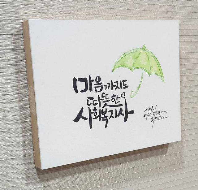 여승수 사무총장이 동료로부터 선물 받은 ‘마음까지도 따뜻한 사회복지사’ 문구가 적힌 캘리그래피 액자 사진.