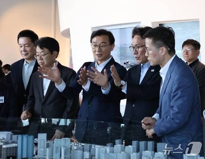 김민석 더불어민주당 대표(오른쪽에서 두 번째)가 17일 오후 부산 동구 부산항국제전시컨벤션센터(BPEX)에서 전재수 부산시장(가운데) 등 지자체 관계자들과 함께 북항재개발 구역 모형을 내려다보며 주요 사업 추진 현황을 점검하고 있다. (전재수 부산시장 개인 SNS 갈무리. 재판매 및 DB금지)