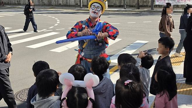 파란 풍선을 꼬아 검을 만드는 삐에로빈과 이를 지켜보고 있는 아이들의 모습. 한 아이 머리엔 먼저 받은 토끼 귀 풍선 머리띠가 씌워져 있다. 백재연 기자