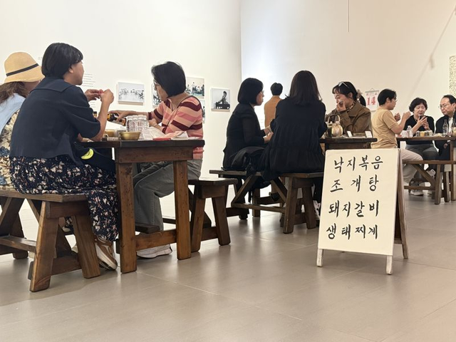 지난 15일 롯데뮤지엄 ‘미드위크 뮤지엄’ 참가자들이 이강소가 선술집으로 꾸린 설치작 ‘소멸’에서 술과 음식을 즐기고 있다. 롯데문화재단 제공