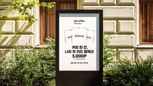 야외에 설치된 ‘더커피(the coffee.)’와 ‘피켓(PICKET)‘의 이색 협업 프로젝트 메인 포스터. <제공=더커피>