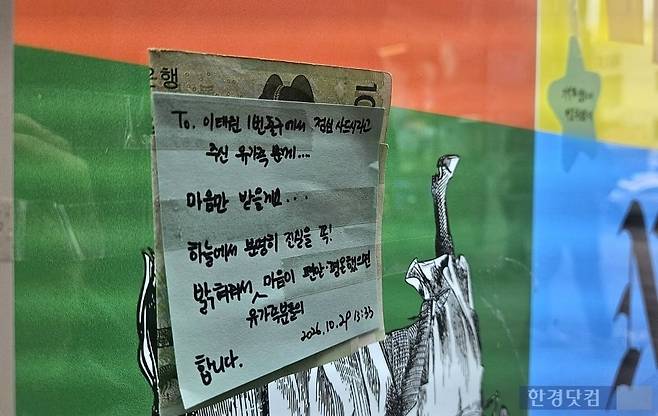 29일 오후 서울 용산구 이태원역 1번 출구 앞 '10·29 기억과 안전의 길'의 빌보드에 2만원이 붙어있다. 역 앞에서 10·29 참사를 기억하자며 사탕을 나눈 김모씨가 유가족에게 점심값을 받고 그대로 빌보드에 메시지와 함께 남기고 왔다. /사진=박수빈 기자